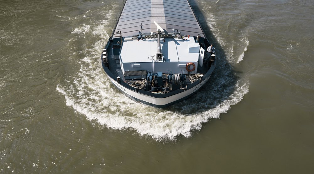 Ein Rheinschiff bei Basel: Während des Hitzesommers 2018 hatte der Fluss zeitweise extreme Niedrigwasserstände – für den Gütertransport in die Schweiz kann das schwerwiegende Folgen haben. (Foto: Keystone-SDA)