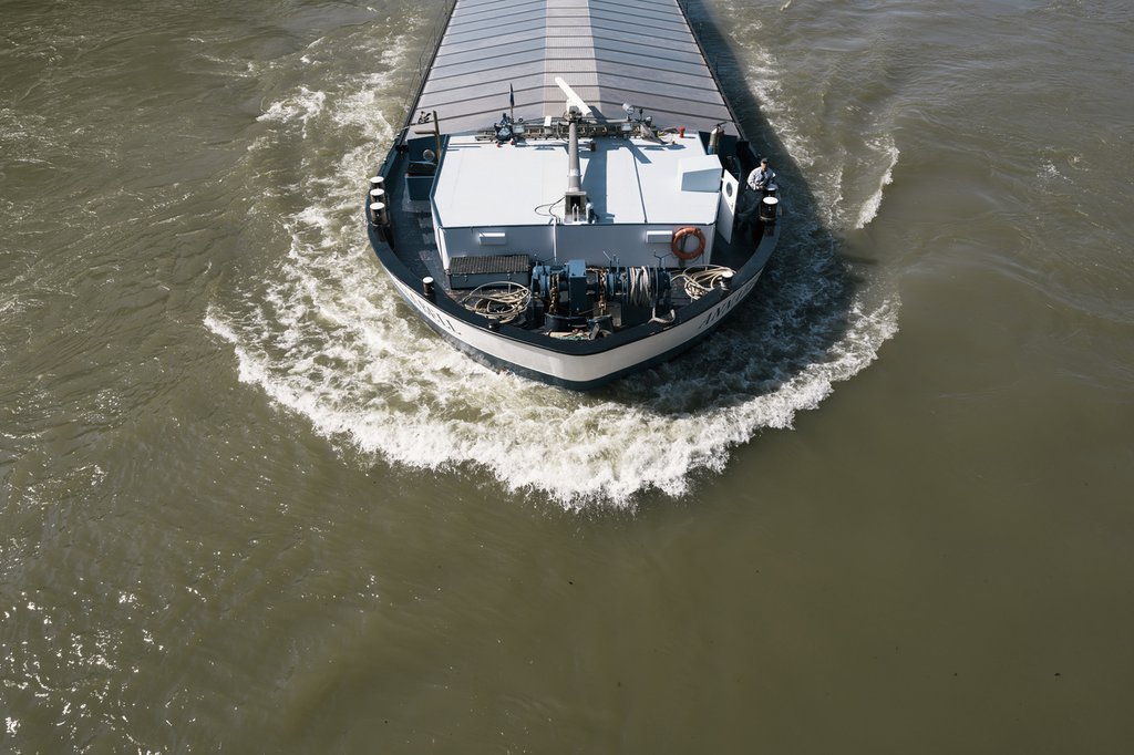 Un bateau rhénan près de Bâle : durant les canicules de l’été 2018, le fleuve a connu des périodes d’étiage extrême, une situation qui peut avoir des conséquences graves sur le transport de marchandises à destination de la Suisse. (Photo : Keystone-SDA)